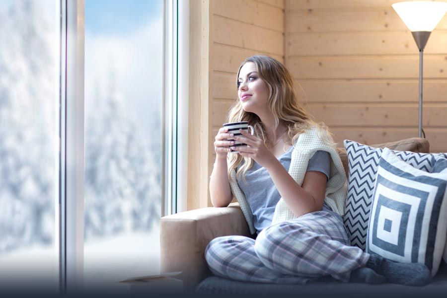 Selbstklebende Isolierfolie auf einem Wohnzimmerfenster mit Winterlandschaft